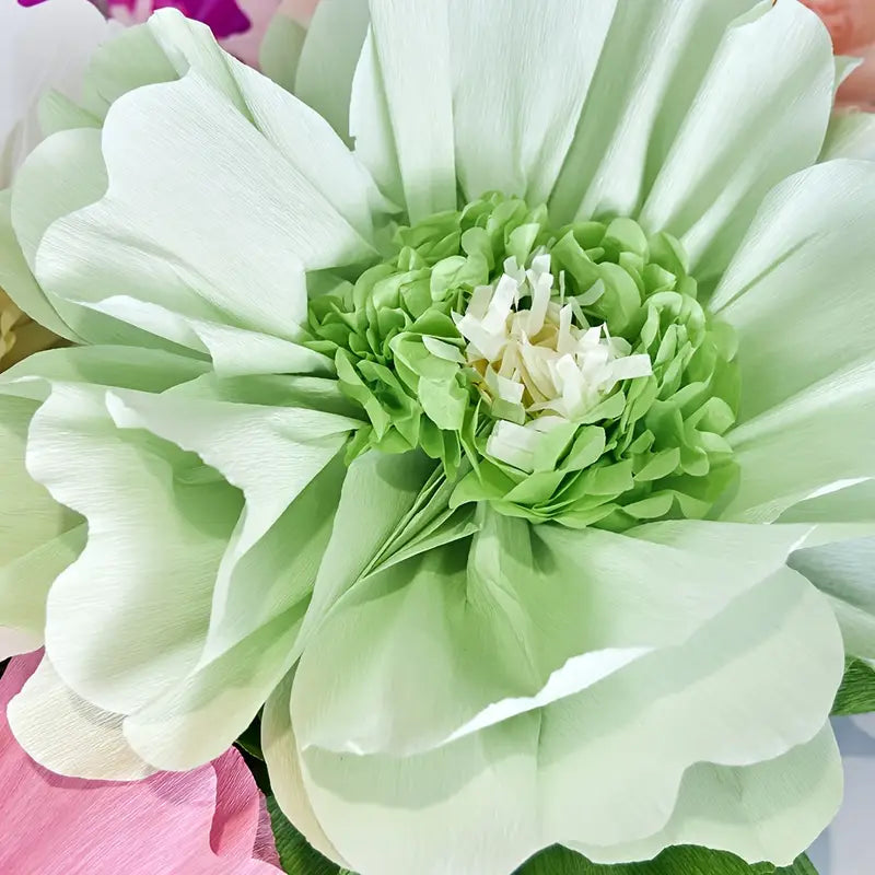 Close-up of green crepe paper flower showing realistic handmade details for decoration.